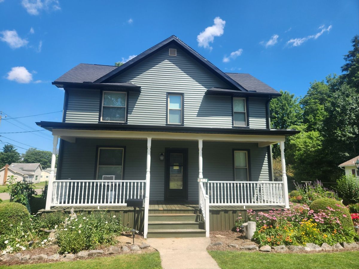 Two-story home with blue-gray siding and a white front porch