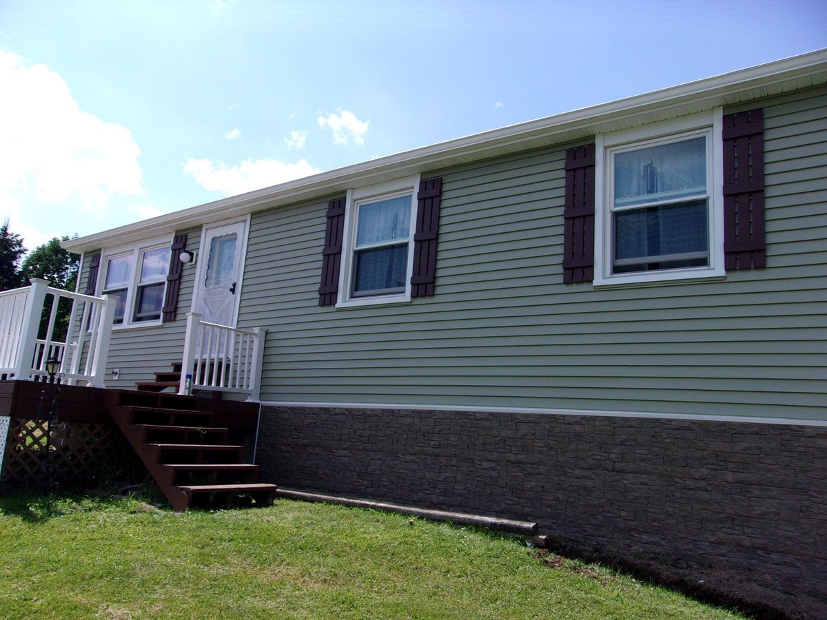 Ranch home with Gentek Juniper Grove siding and Novik stone skirting