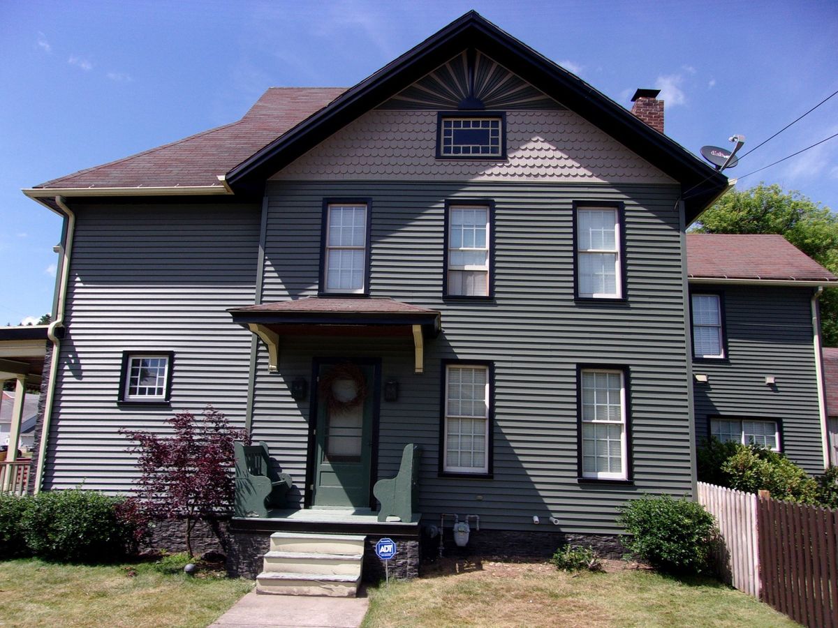 Gentek Moonlit Moss siding with black window trim and Novik stacked stone
