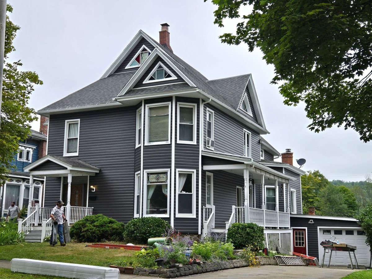 Gray Victorian home with crisp white trim after an exterior renovation